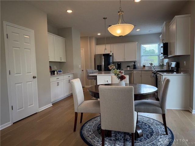 11916 Abbeytown Dr, Colerain Twp, OH 45251 - kitchen with appliances with stainless steel finishes, light wood-style floors, a center island, recessed lighting, and white cabinetry