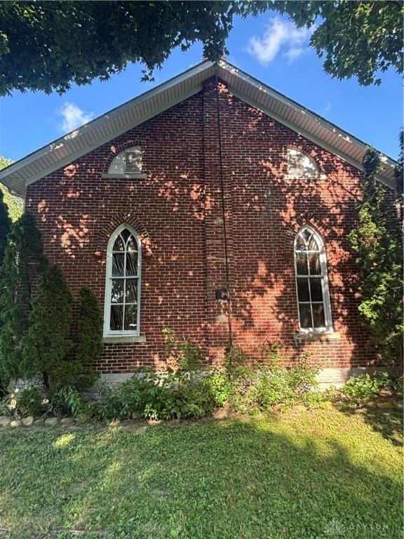 6008 Delisle-Fourman Rd, Arcanum, OH 45304 - view of side of property featuring brick siding and a yard