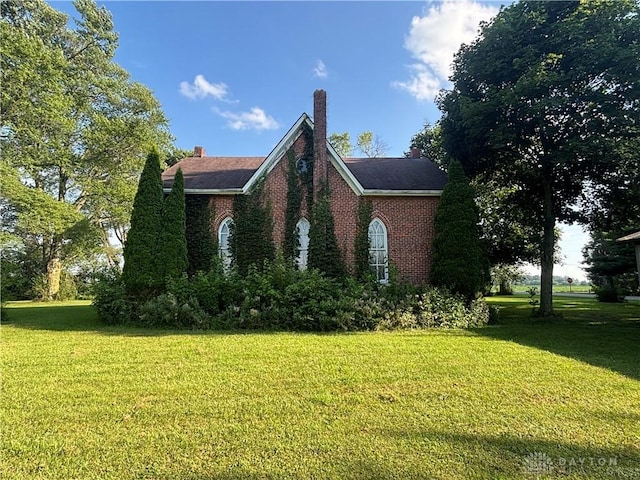 6008 Delisle-Fourman Rd, Arcanum, OH 45304 - view of side of property with a yard, brick siding, and a chimney