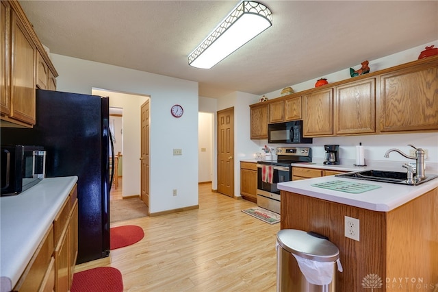 215 Christina Way, Franklin, OH 45005 - kitchen with black appliances, brown cabinets, light countertops, and light wood finished floors
