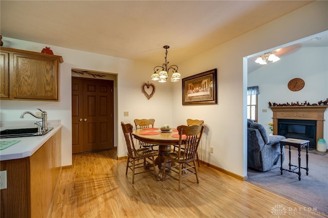 215 Christina Way, Franklin, OH 45005 - dining space with a chandelier, light wood-style flooring, and a glass covered fireplace
