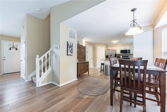 947 Stone Ridge Ln, Lebanon, OH 45036 - dining room featuring light wood-style flooring, stairway, and a textured ceiling