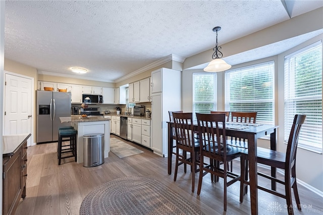 947 Stone Ridge Ln, Lebanon, OH 45036 - kitchen with appliances with stainless steel finishes, a textured ceiling, healthy amount of natural light, light wood-style flooring, and ornamental molding