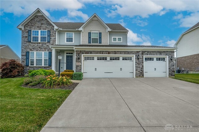 9282 Maple Brook St, Clearcreek Twp, OH 45458 - view of front facade featuring stone siding, driveway, a front lawn, and an attached garage