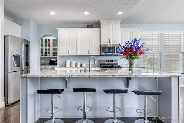 9282 Maple Brook St, Clearcreek Twp, OH 45458 - kitchen with appliances with stainless steel finishes, white cabinetry, dark wood-style floors, a textured ceiling, and light stone countertops