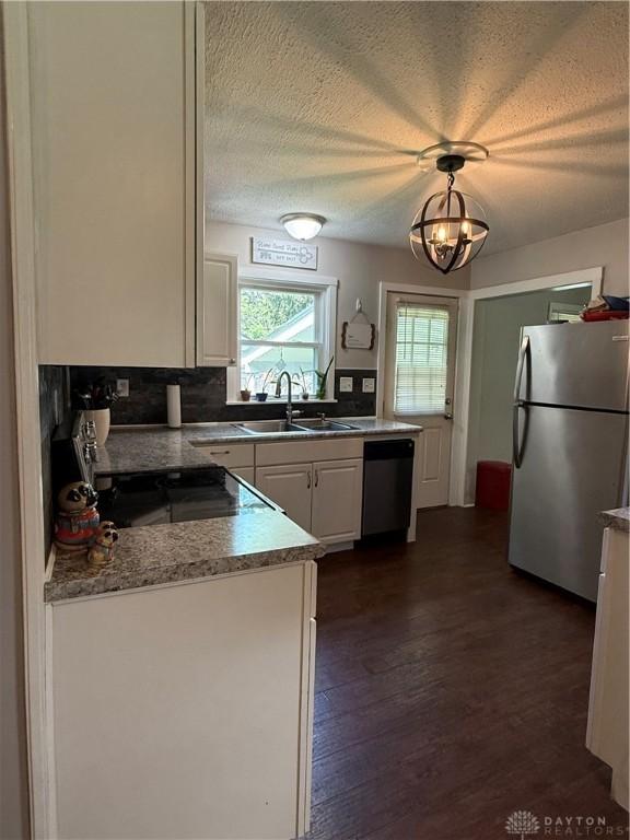 5001 Central Ave, Middletown, OH 45044 - kitchen with appliances with stainless steel finishes, white cabinetry, dark wood-style floors, a textured ceiling, and decorative backsplash
