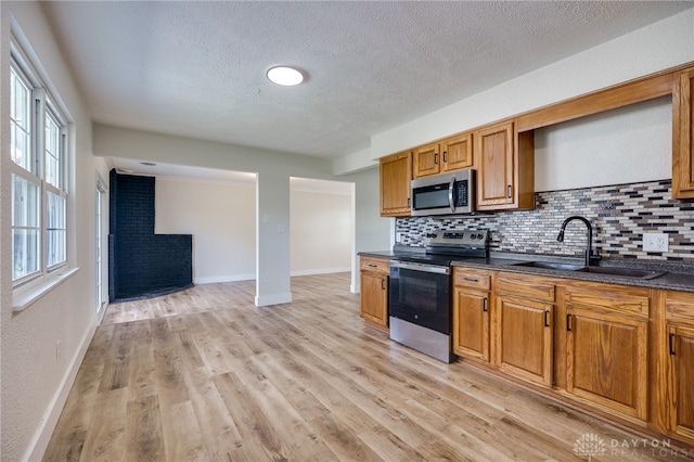 3183 Myers Tillman Rd, Arcanum, OH 45304 - kitchen featuring appliances with stainless steel finishes, decorative backsplash, a textured ceiling, and brown cabinetry