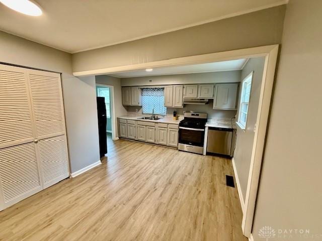 135 B St, Wilmington, OH 45177 - kitchen with stainless steel stove, light countertops, light wood-style floors, under cabinet range hood, and gray cabinetry