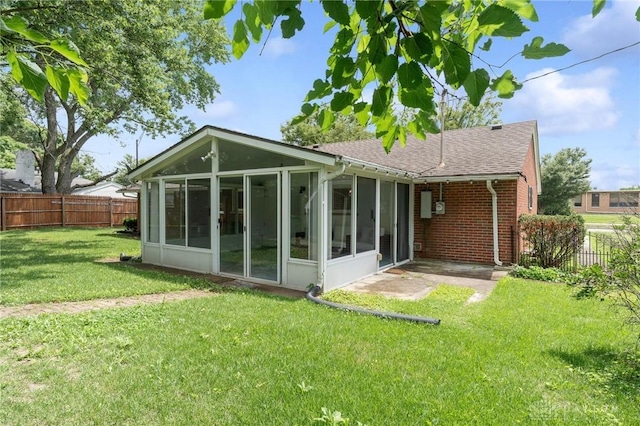829 E Stroop Rd, Kettering, OH 45429 - back of property with a sunroom, a fenced backyard, a shingled roof, and brick siding