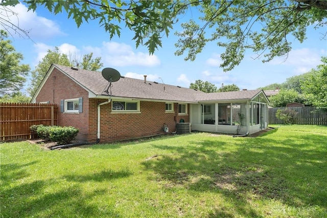 829 E Stroop Rd, Kettering, OH 45429 - rear view of house with brick siding, a sunroom, a fenced backyard, and a shingled roof