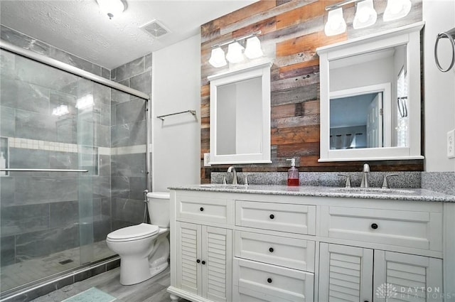 3492 King Edward Way, Beavercreek, OH 45431 - bathroom with double vanity, a shower stall, wood finished floors, and a textured ceiling