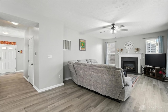 3492 King Edward Way, Beavercreek, OH 45431 - living room with light wood-style flooring, ceiling fan, and a fireplace with flush hearth