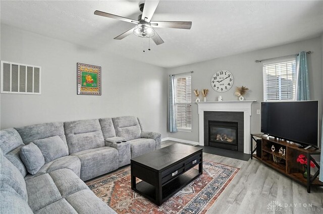 3492 King Edward Way, Beavercreek, OH 45431 - living room featuring healthy amount of natural light, light wood finished floors, ceiling fan, and a fireplace with flush hearth