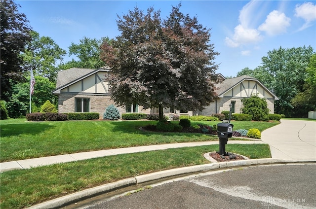 3820 Shagbark Ln, Beavercreek, OH 45440 - english style home featuring a front lawn, concrete driveway, and brick siding