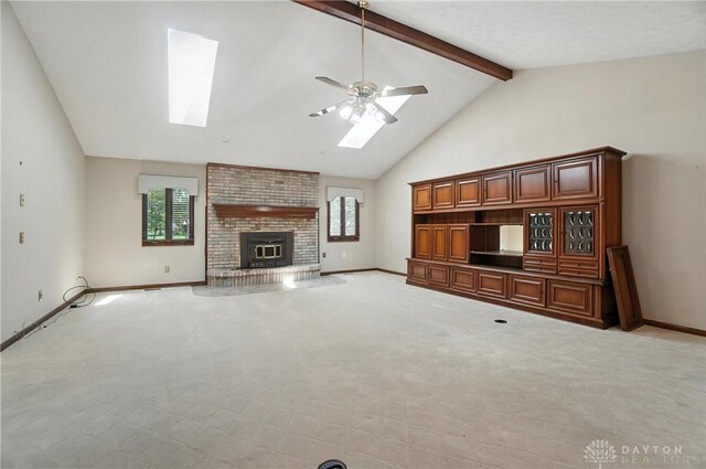 3820 Shagbark Ln, Beavercreek, OH 45440 - unfurnished living room featuring a skylight, ceiling fan, beamed ceiling, a fireplace, and high vaulted ceiling