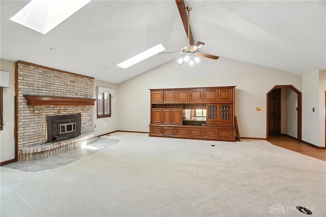 3820 Shagbark Ln, Beavercreek, OH 45440 - unfurnished living room featuring a skylight, light carpet, ceiling fan, beamed ceiling, and high vaulted ceiling