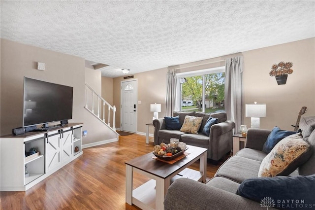 5431 Flicker Way, Dayton, OH 45424 - living room featuring wood finished floors, stairway, and a textured ceiling