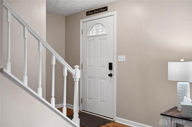 5431 Flicker Way, Dayton, OH 45424 - entrance foyer featuring stairs, wood finished floors, and a textured ceiling