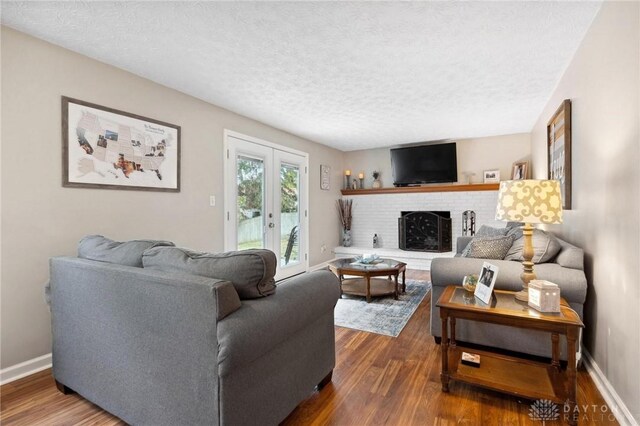 5431 Flicker Way, Dayton, OH 45424 - living area featuring dark wood-style floors, a textured ceiling, and a brick fireplace