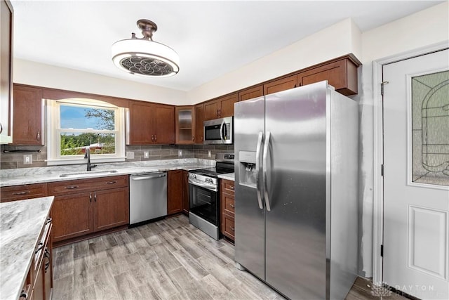 19551 US Highway 68, Fayetteville, OH 45118 - kitchen featuring appliances with stainless steel finishes, decorative backsplash, glass insert cabinets, light wood finished floors, and light stone countertops