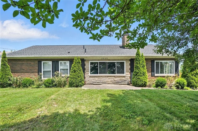 4503 Central Ave, Middletown, OH 45044 - rear view of property featuring a chimney, a lawn, a shingled roof, and stone siding