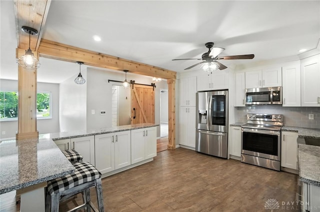 4503 Central Ave, Middletown, OH 45044 - kitchen featuring stainless steel appliances, a barn door, decorative backsplash, ceiling fan, and recessed lighting