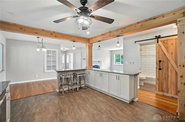 4503 Central Ave, Middletown, OH 45044 - kitchen featuring a barn door, dark wood finished floors, stone counters, white cabinetry, and beamed ceiling