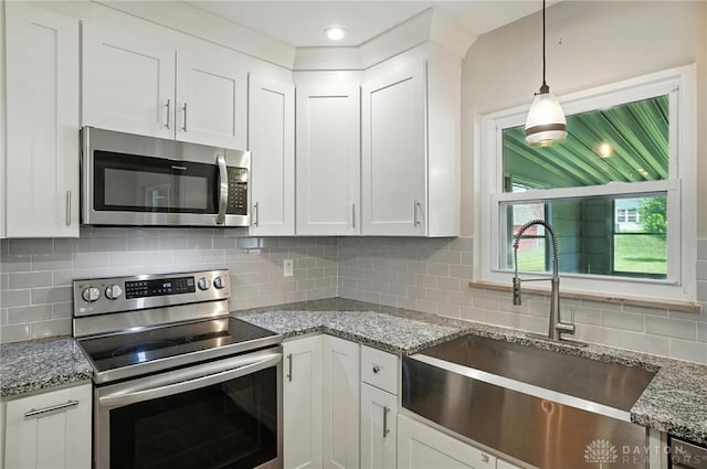 4503 Central Ave, Middletown, OH 45044 - kitchen with appliances with stainless steel finishes, white cabinets, light stone countertops, and pendant lighting