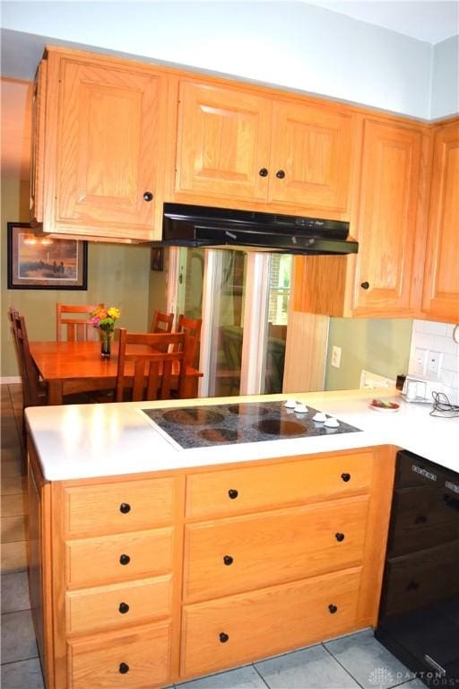 3235 W Ziegler Rd, Piqua, OH 45356 - kitchen with black appliances, under cabinet range hood, light tile patterned floors, a peninsula, and light countertops