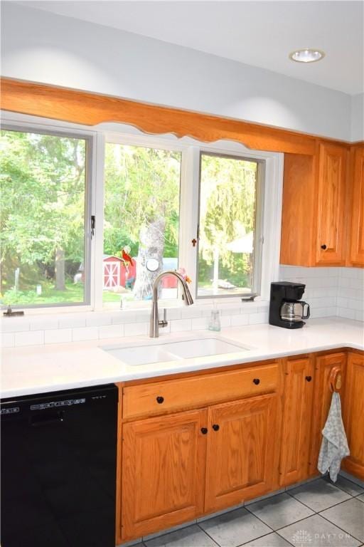 3235 W Ziegler Rd, Piqua, OH 45356 - kitchen with black dishwasher, light tile patterned floors, decorative backsplash, light countertops, and brown cabinets