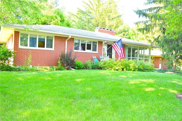 3235 W Ziegler Rd, Piqua, OH 45356 - view of front of home with brick siding, a front lawn, and a chimney