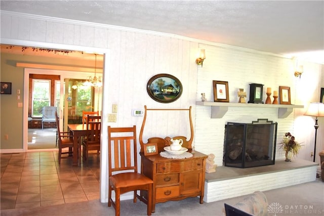 3235 W Ziegler Rd, Piqua, OH 45356 - living room with a brick fireplace, a chandelier, tile patterned floors, and crown molding