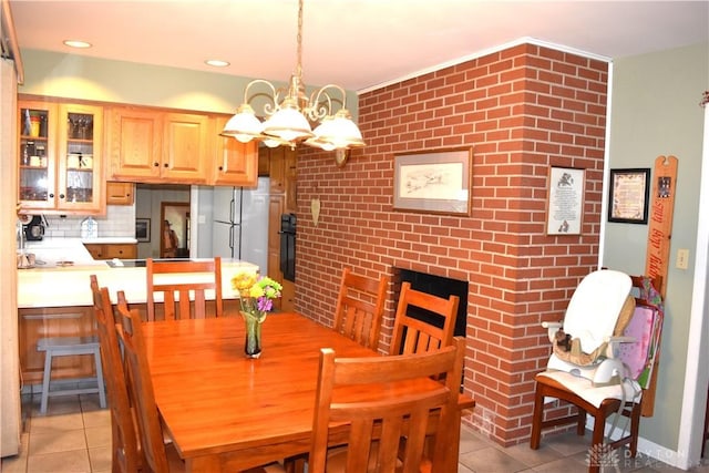 3235 W Ziegler Rd, Piqua, OH 45356 - dining space featuring light tile patterned floors, a chandelier, and brick wall