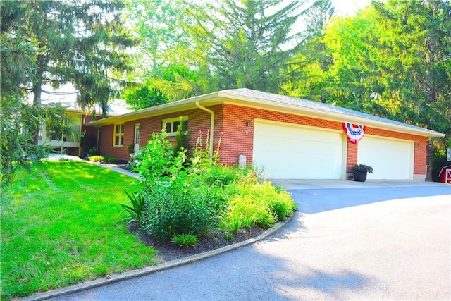 3235 W Ziegler Rd, Piqua, OH 45356 - single story home featuring an attached garage, driveway, brick siding, and a front yard