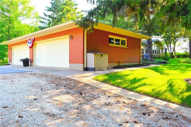 3235 W Ziegler Rd, Piqua, OH 45356 - view of home's exterior with a garage, a lawn, brick siding, and driveway
