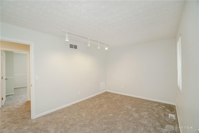 9446 Haddington Ct Unit 200, Cincinnati, OH 45251 - spare room featuring rail lighting, light carpet, and a textured ceiling