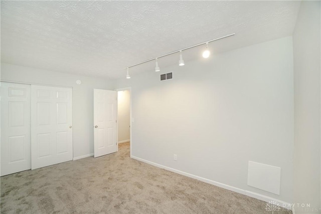 9446 Haddington Ct Unit 200, Cincinnati, OH 45251 - unfurnished bedroom featuring track lighting, carpet floors, a closet, and a textured ceiling