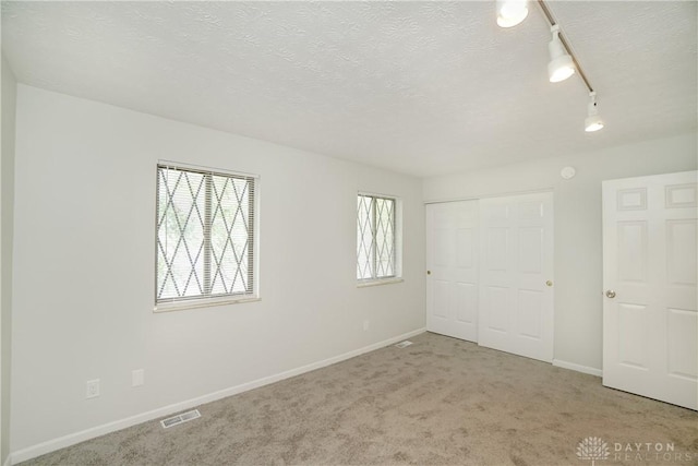 9446 Haddington Ct Unit 200, Cincinnati, OH 45251 - unfurnished bedroom with rail lighting, a closet, carpet floors, and a textured ceiling