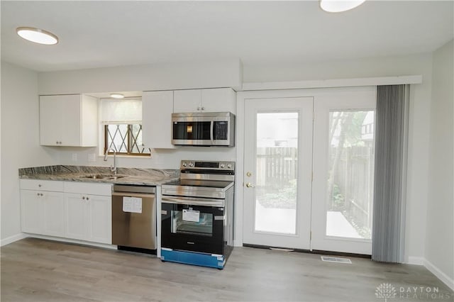 9446 Haddington Ct Unit 200, Cincinnati, OH 45251 - kitchen featuring appliances with stainless steel finishes, white cabinetry, stone counters, and light wood-type flooring