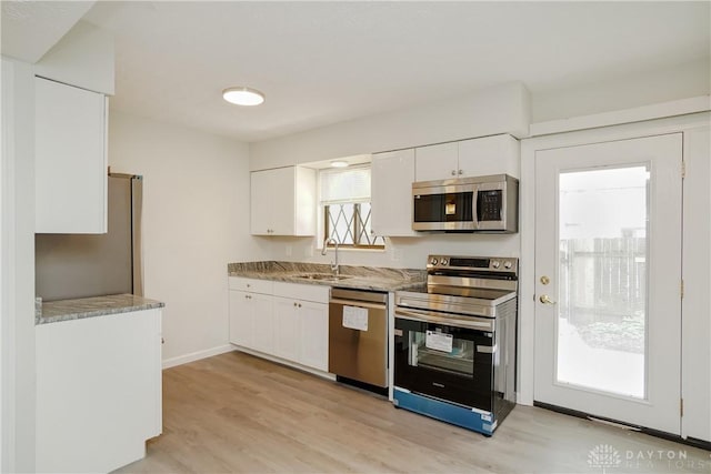 9446 Haddington Ct Unit 200, Cincinnati, OH 45251 - kitchen featuring stainless steel appliances, white cabinetry, light wood finished floors, and light stone countertops