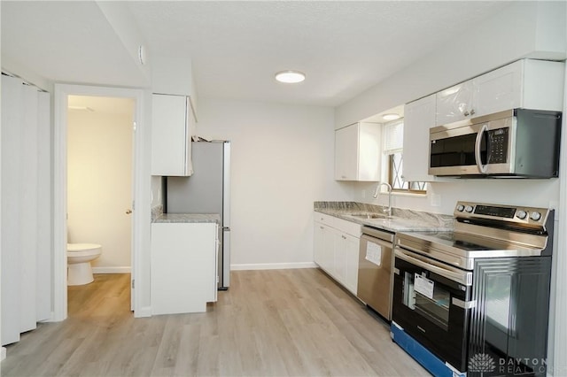 9446 Haddington Ct Unit 200, Cincinnati, OH 45251 - kitchen featuring appliances with stainless steel finishes, light wood-type flooring, and white cabinetry