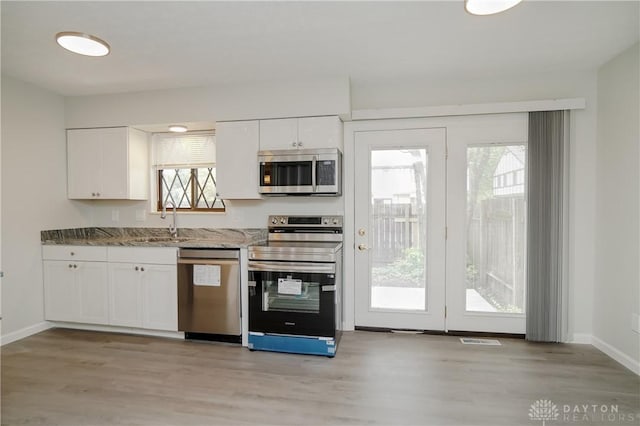 9446 Haddington Ct Unit 200, Cincinnati, OH 45251 - kitchen featuring appliances with stainless steel finishes, light wood-style floors, and white cabinetry