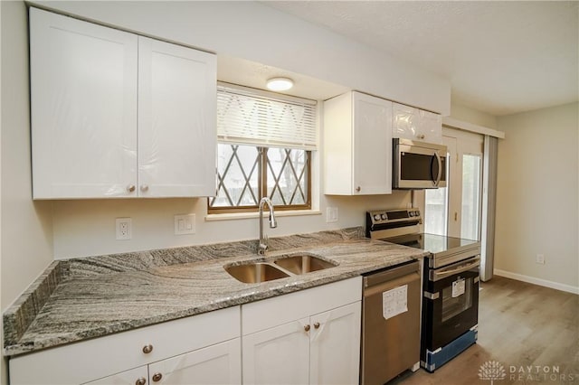 9446 Haddington Ct Unit 200, Cincinnati, OH 45251 - kitchen with stainless steel appliances, white cabinets, light wood-type flooring, and light stone countertops