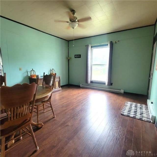 300 S Evans St, Saratoga, IN 47382 - dining area with baseboard heating, a ceiling fan, wood finished floors, and a baseboard radiator