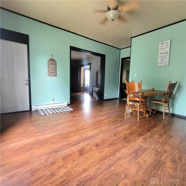 300 S Evans St, Saratoga, IN 47382 - dining space featuring a baseboard heating unit, wood finished floors, and a ceiling fan