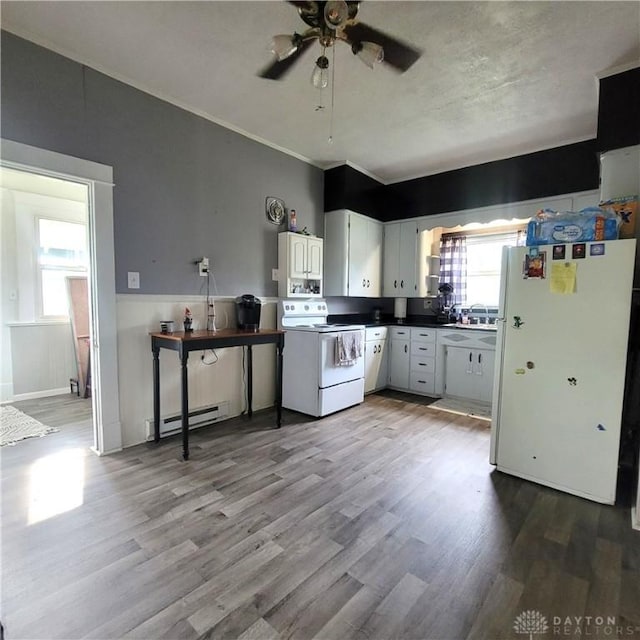 300 S Evans St, Saratoga, IN 47382 - kitchen featuring white appliances, baseboard heating, wood finished floors, ceiling fan, and plenty of natural light