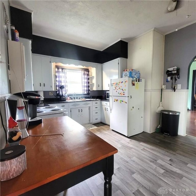 300 S Evans St, Saratoga, IN 47382 - kitchen with freestanding refrigerator, light wood-type flooring, and white cabinets
