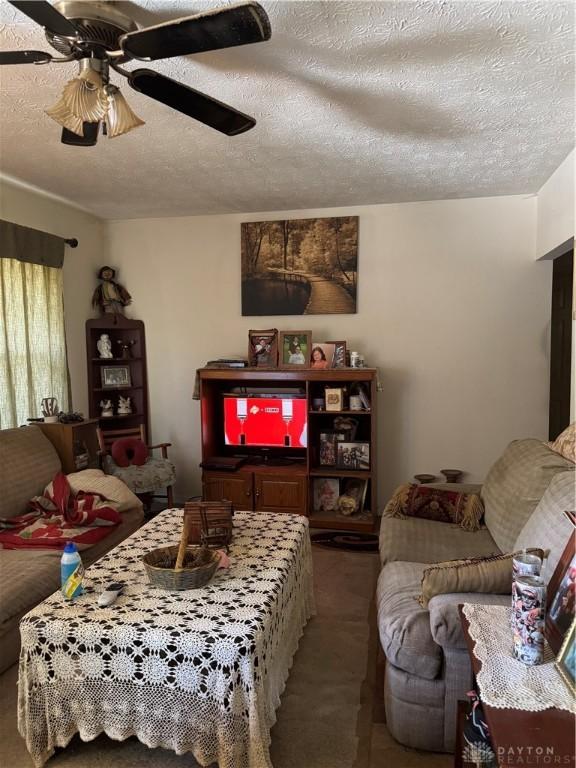 8211 Sue Ave, Franklin, OH 45005 - living room featuring carpet flooring, a textured ceiling, and a ceiling fan