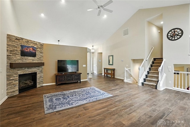 2210 Hidden Woods Blvd, Beavercreek, OH 45431 - living area featuring high vaulted ceiling, a ceiling fan, wood finished floors, a stone fireplace, and stairs