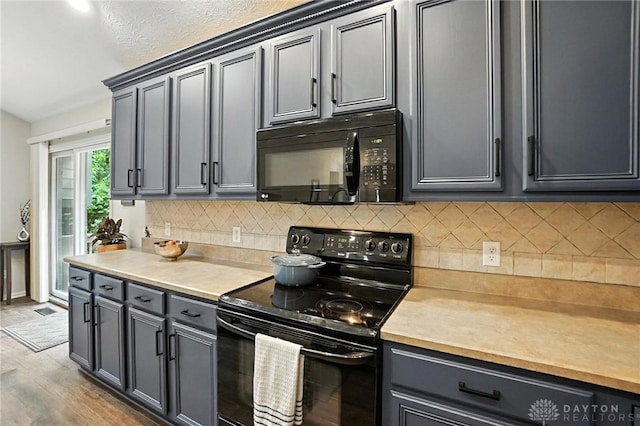 2210 Hidden Woods Blvd, Beavercreek, OH 45431 - kitchen featuring black appliances, light countertops, backsplash, and wood finished floors